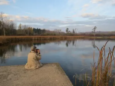 Man sitting at water's edge at Laurel Creek reservoir